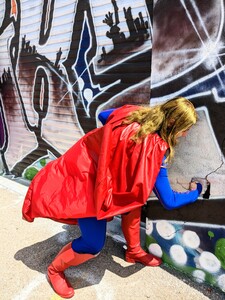 Super Girl de l'association cosplayarts66 qui frappe un mur déjà abîmé l'effet est super stylé
