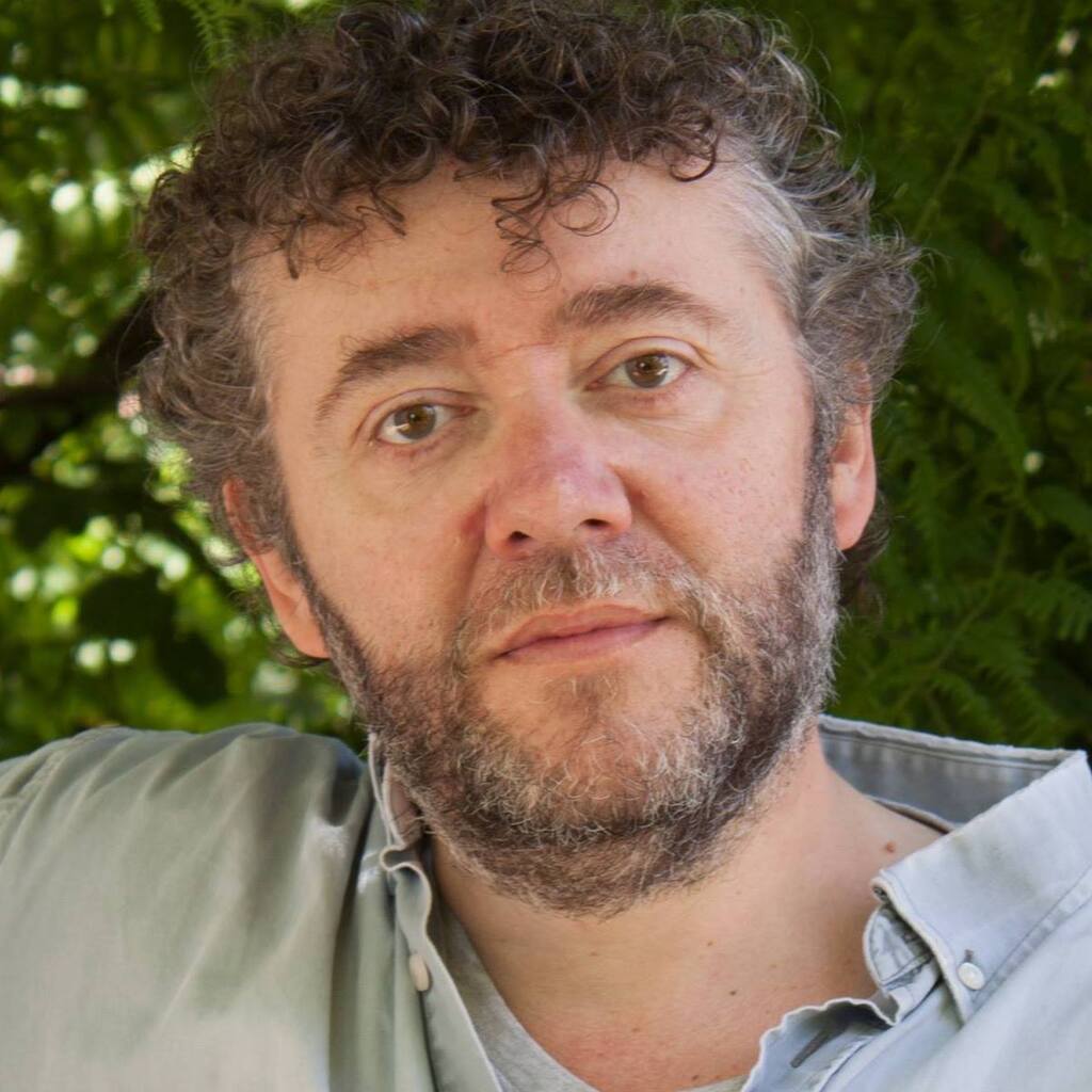 Fred Saurel est un homme aux cheveux bouclés et possédant une barbe grise