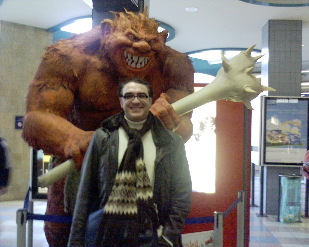 Photo de Fabien Tillon, qui pose avec une statue géante d'ogre de bande dessinée, qui semble prête à l’assommer !