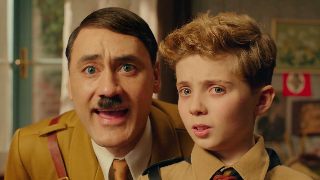 Hitler qui parle à un petit garçon en faisant une grimace amusante.