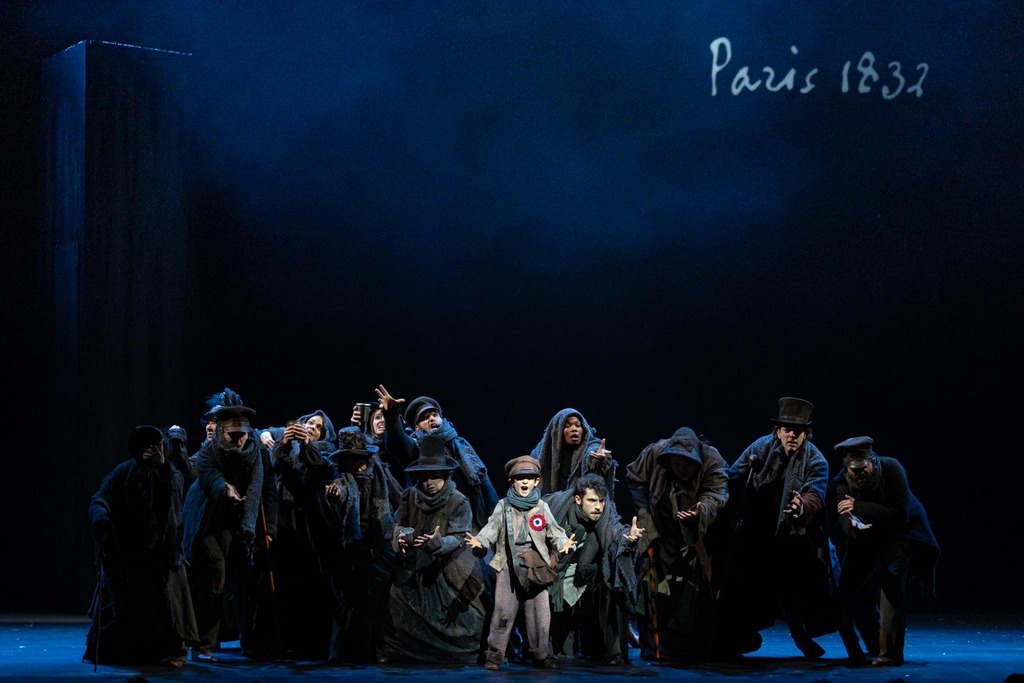 Gavroche chantant, entouré par les mendiants.