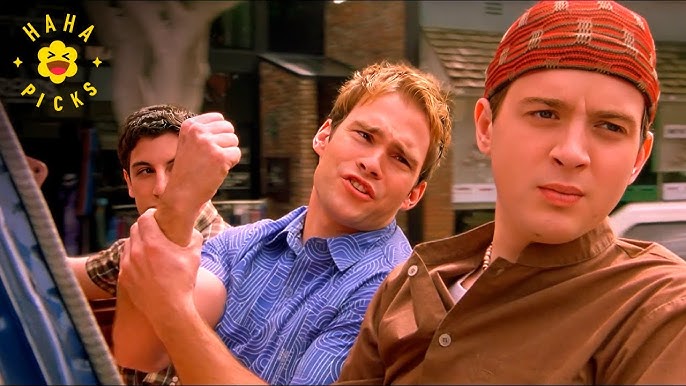 L'image présente Flinch, Stifler et Jom dans une voiture. Flinch est vêtu d'un bonnet tibétain rouge et d'une chemise marron, qui suffisent à eux seuls à décourager toute forme d'appropriation culturelle. Stifler fait un geste équivoque de la main, et Jim regarde de côté. Difficile de vous dire lequel nous fait le plus rire.