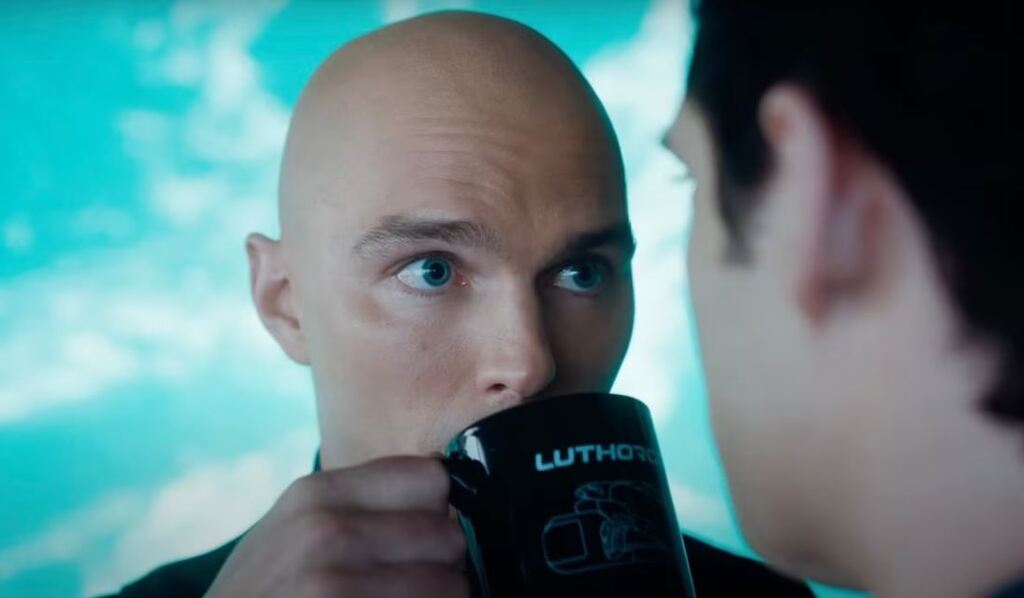 Lex Luthor joue l'imbécile et regarde Superman avec un air faussement étonné et moqueur. Il est en train de boire une tasse Luthorcorp. C'est une provocation contre son rival.