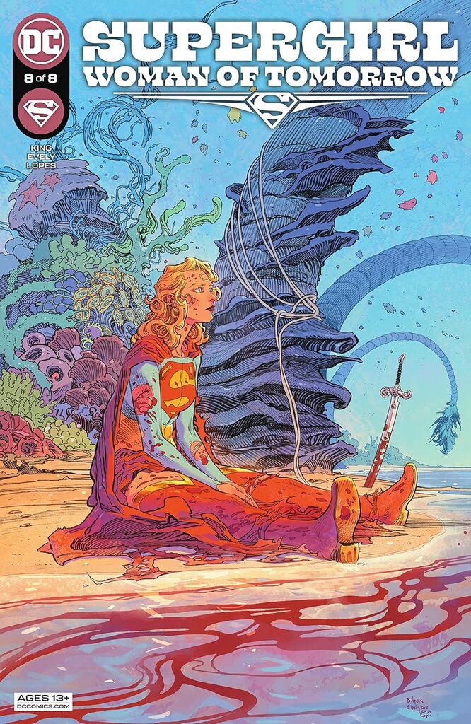 Page du comics Supergirl. Elle regarde l'horizon assise sur une plage alien aux couleurs pastel et à la flore extraterrestre. Elle est tachée de sang et un sabre est plantée sur le sol près d'elle.