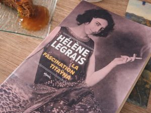 Photo présentant le livre d'Hélène Legrais la fascination de Tataÿna avec Elisabeth sauvy fumant une cigarette sur la couverture violette, autour : une tasse game of thrones et un gâteau