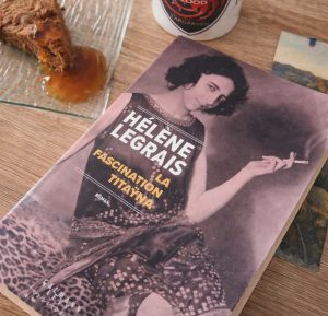 Photo présentant le livre d'Hélène Legrais la fascination de Tataÿna avec Elisabeth sauvy fumant une cigarette sur la couverture violette, autour : une tasse game of thrones et un gâteau