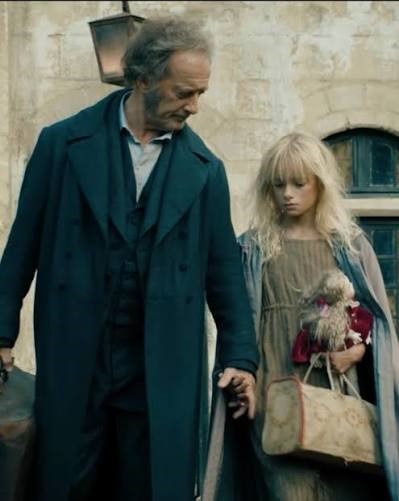 Cosette enfant donnant la main à Jean Valjean. Elle tient dans l’autre main sa poupée Catherine.