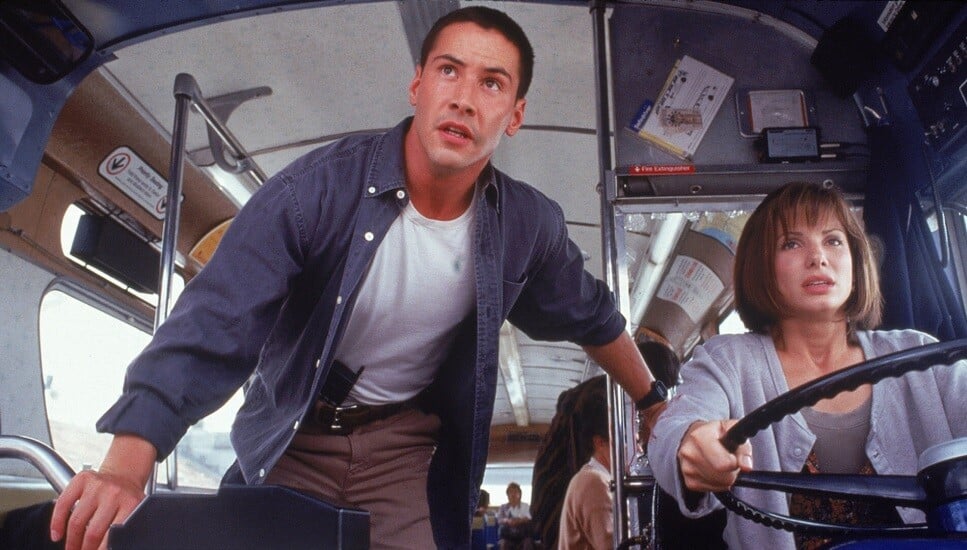Photographie du film Speed (1994), montrant Keanu Reeves et Sandra Bullock à bord du bus piégé, dans lequel le personnage d’Annie Porter prend le volant.